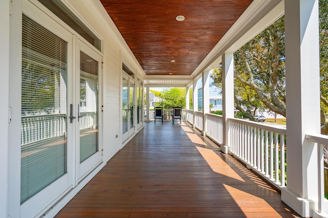 wooden terrace with a porch and french doors