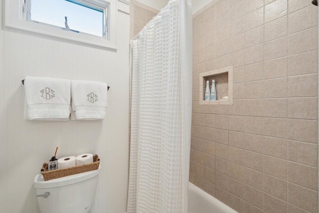 bathroom featuring shower / bath combination with curtain and toilet