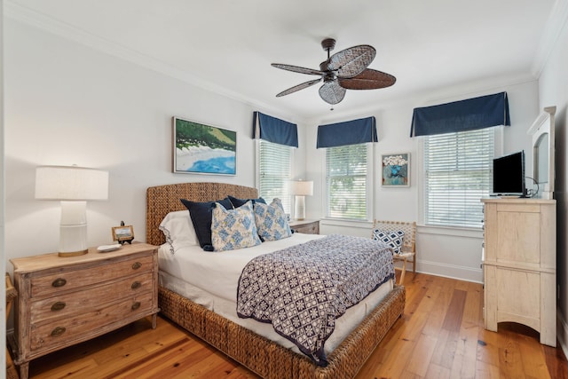 bedroom featuring ceiling fan, ornamental molding, baseboards, and light wood finished floors