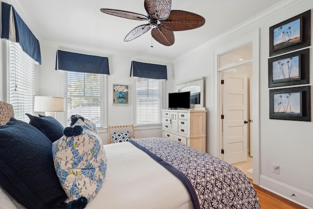 bedroom featuring crown molding, a ceiling fan, baseboards, and light wood-style floors