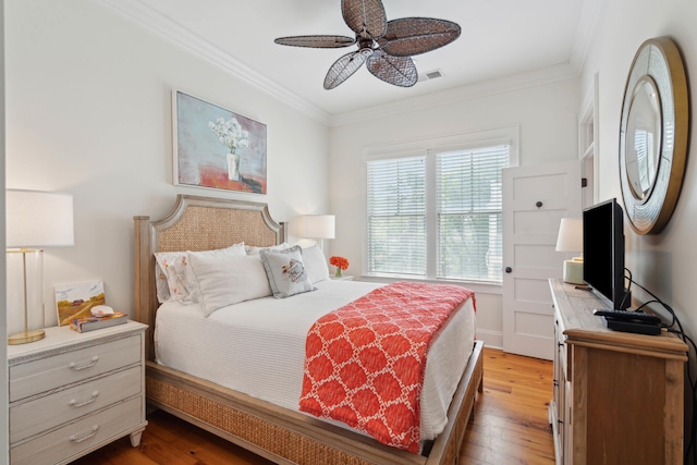 bedroom with wood-type flooring, crown molding, and visible vents