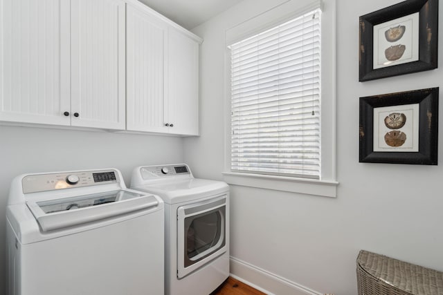 laundry area featuring a healthy amount of sunlight, baseboards, cabinet space, and washer and dryer