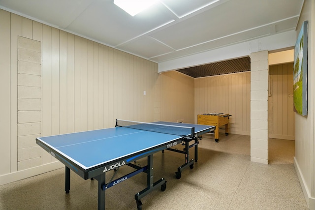 game room featuring baseboards and wood walls