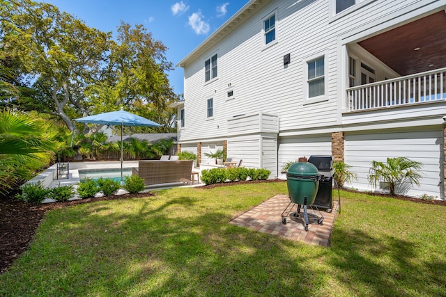rear view of property featuring a yard, an outdoor pool, and a patio area