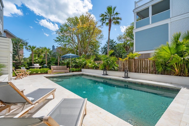 view of swimming pool with a patio, fence, and a fenced in pool