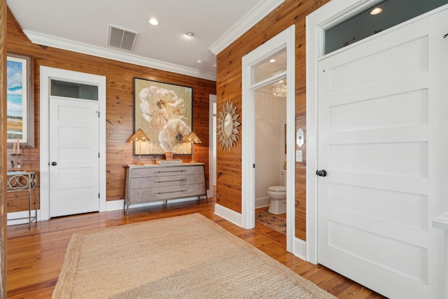 interior space featuring visible vents, crown molding, wooden walls, recessed lighting, and light wood-type flooring