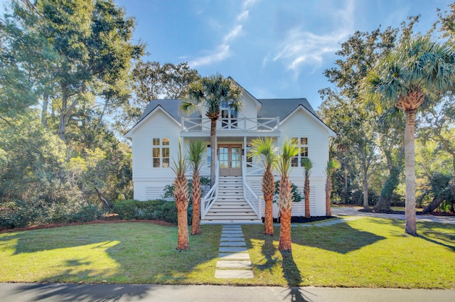 view of front of house with a porch, a balcony, and a front lawn