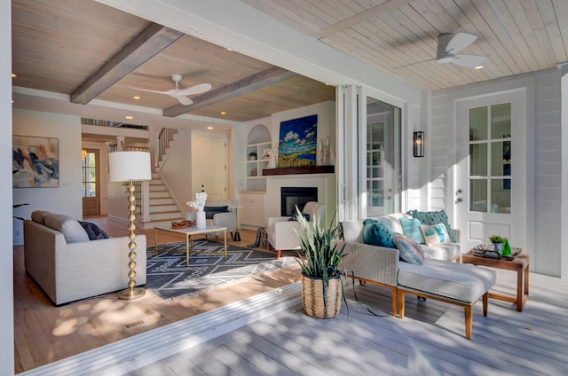 living room featuring hardwood / wood-style floors, wooden ceiling, ceiling fan, and beam ceiling