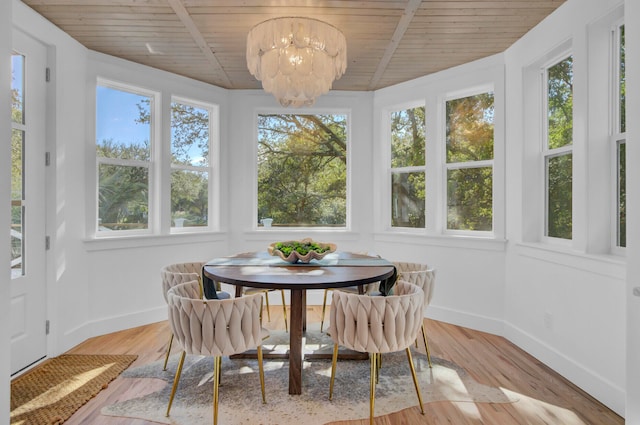 sunroom / solarium with a chandelier and wooden ceiling