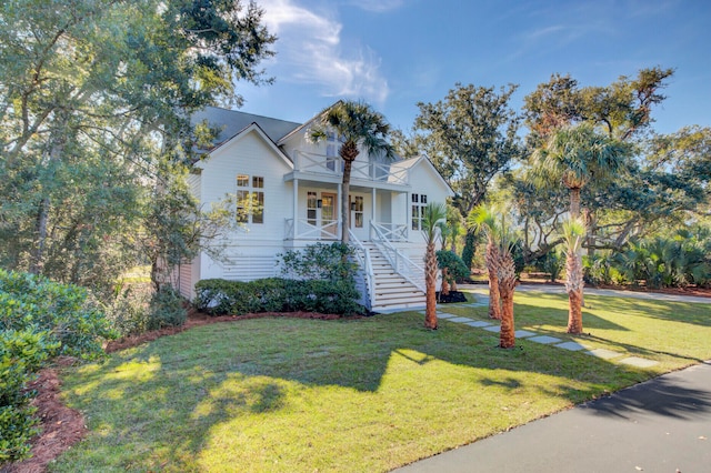 view of front of house featuring a balcony, covered porch, and a front yard