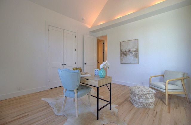 office area with light hardwood / wood-style flooring and vaulted ceiling