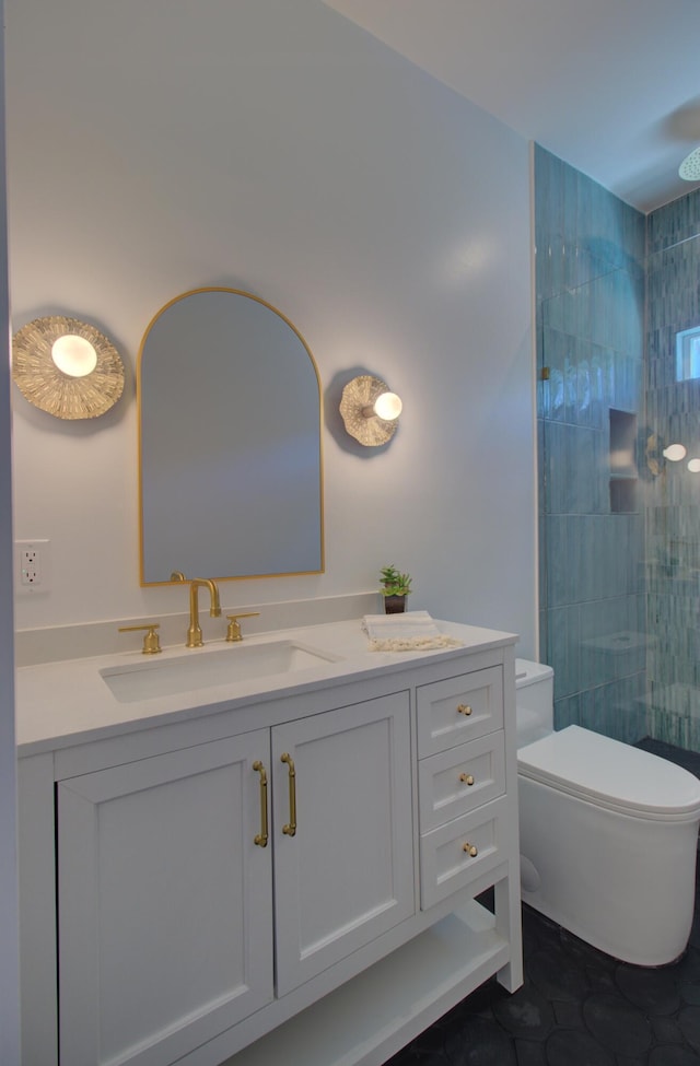 bathroom featuring vanity, toilet, tile patterned flooring, and a tile shower