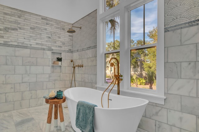 bathroom with a tub to relax in and tile walls