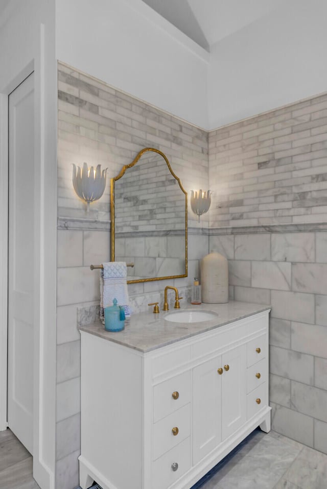 bathroom with vanity and tile walls