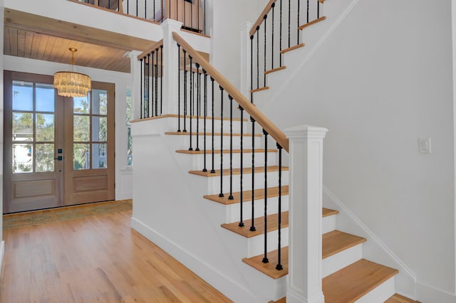 entryway featuring hardwood / wood-style floors, wood ceiling, an inviting chandelier, and french doors