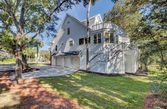 exterior space with a balcony, a front lawn, and a garage