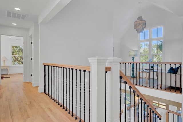 corridor with an inviting chandelier and hardwood / wood-style flooring