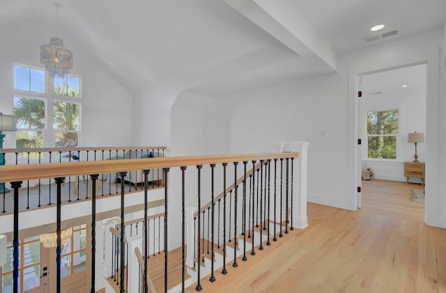 corridor with a notable chandelier and light hardwood / wood-style floors