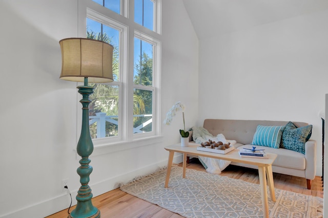 sitting room with wood-type flooring and vaulted ceiling