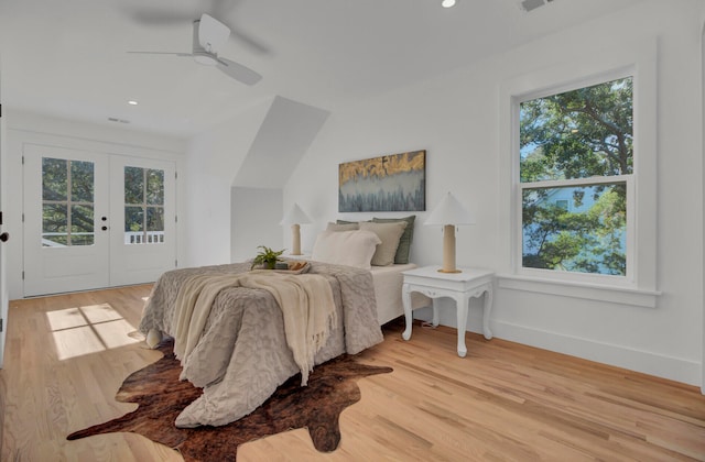 bedroom featuring access to exterior, light hardwood / wood-style flooring, and multiple windows