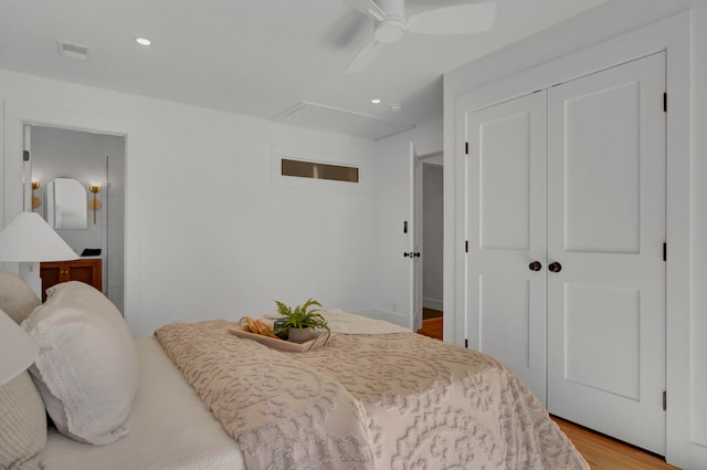 bedroom with a closet, light hardwood / wood-style floors, and ceiling fan