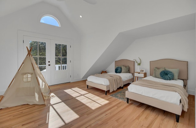 bedroom featuring access to outside, french doors, lofted ceiling, and light wood-type flooring