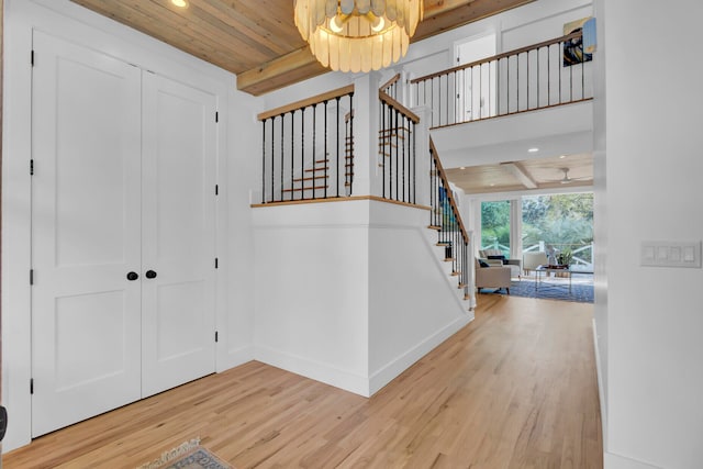 foyer with a chandelier, hardwood / wood-style floors, beam ceiling, and wood ceiling