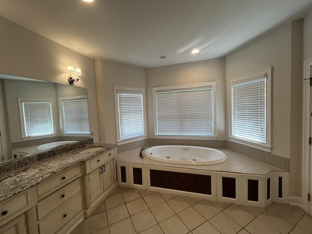 bathroom with a healthy amount of sunlight, tile patterned floors, and a tub with jets