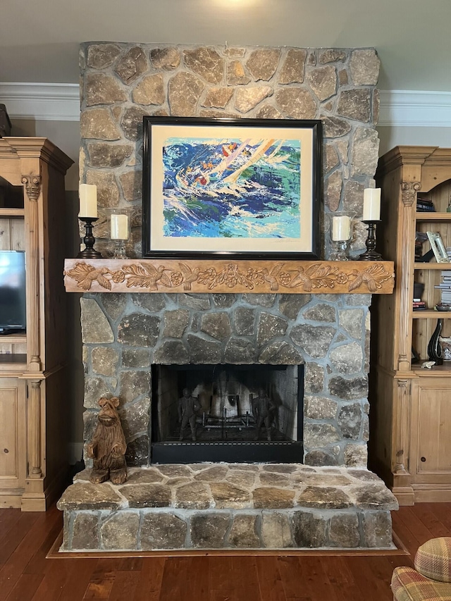 interior details with crown molding, wood finished floors, and a fireplace