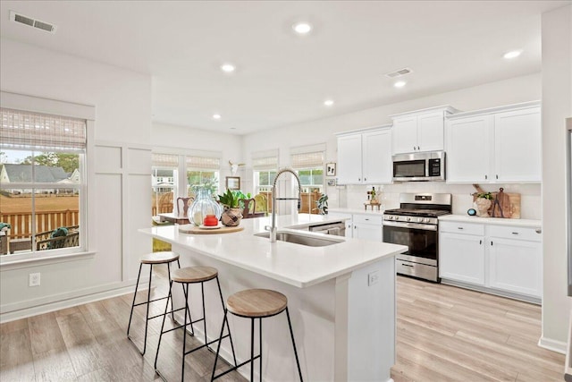 kitchen featuring light hardwood / wood-style floors, sink, stainless steel appliances, and white cabinetry