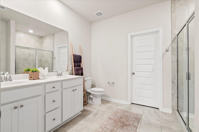 bathroom with a shower with shower door, vanity, tile patterned flooring, and toilet