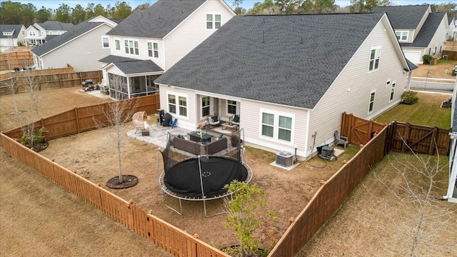 rear view of house with a trampoline, central AC, and a patio