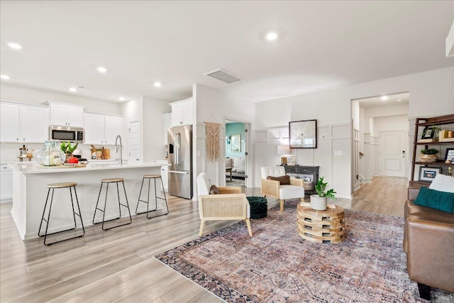 living room with sink and light hardwood / wood-style flooring