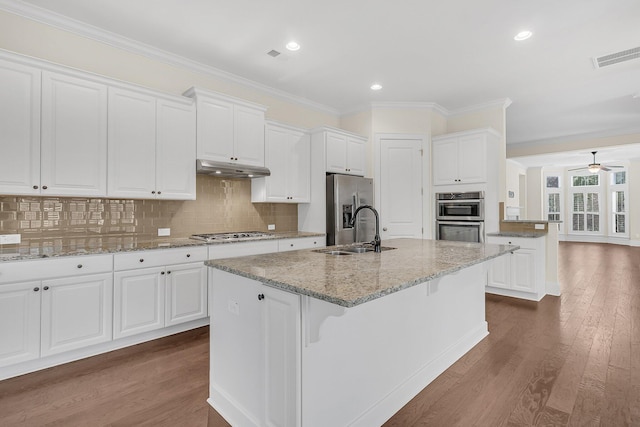 kitchen with under cabinet range hood, stainless steel appliances, dark wood-type flooring, and a sink