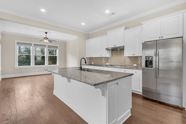 kitchen featuring ornamental molding, a sink, under cabinet range hood, appliances with stainless steel finishes, and dark wood-style flooring