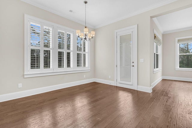 unfurnished dining area with baseboards, crown molding, an inviting chandelier, and wood finished floors