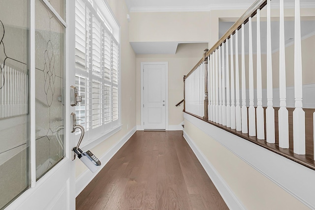 hallway featuring stairway, crown molding, baseboards, and wood finished floors