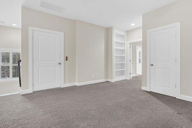 unfurnished room with visible vents, baseboards, built in features, carpet floors, and recessed lighting