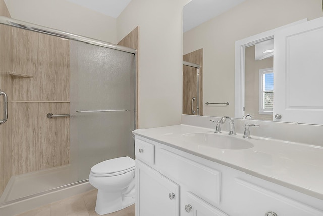 bathroom featuring toilet, a stall shower, and vanity