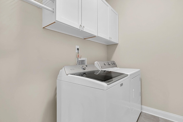 laundry area with cabinet space, washer and dryer, and baseboards