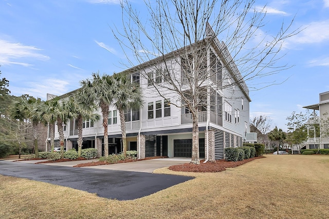 multi unit property with concrete driveway, a garage, and a front yard