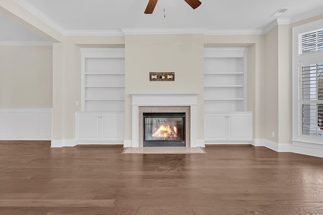 unfurnished living room with built in shelves, wood finished floors, and ornamental molding