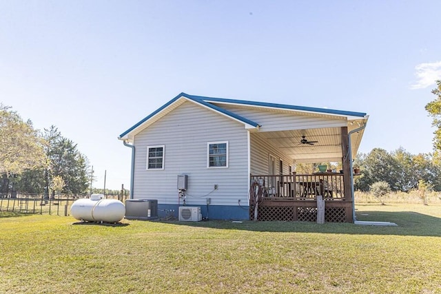 view of side of property with covered porch, cooling unit, ceiling fan, and a yard