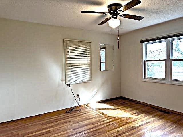 empty room featuring a textured ceiling, hardwood / wood-style floors, and ceiling fan