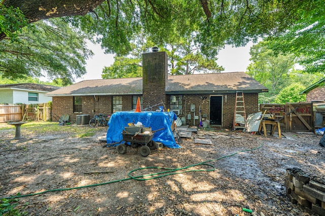 1004 Miles Jamison Rd, Summerville, SC 29485 - back of house with brick siding, a chimney, a fenced backyard, roof with shingles, and central AC