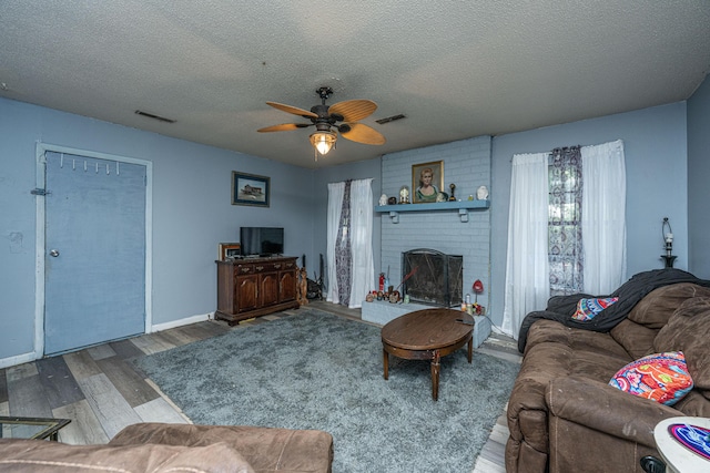 1004 Miles Jamison Rd, Summerville, SC 29485 - living room with wood finished floors, a ceiling fan, a fireplace, a textured ceiling, and baseboards