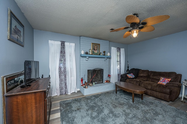 1004 Miles Jamison Rd, Summerville, SC 29485 - living room with wood finished floors, a textured ceiling, a fireplace, and a ceiling fan