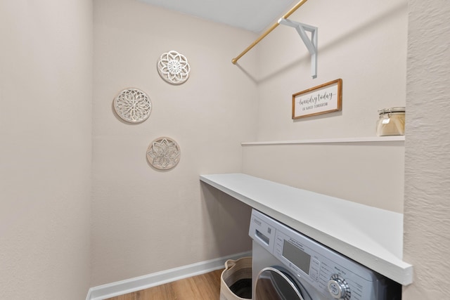 laundry room with laundry area, baseboards, washer / clothes dryer, and wood finished floors