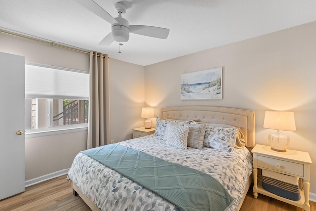 bedroom featuring a ceiling fan, baseboards, and wood finished floors