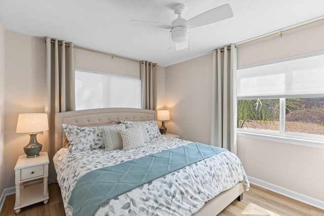 bedroom with ceiling fan, baseboards, and wood finished floors